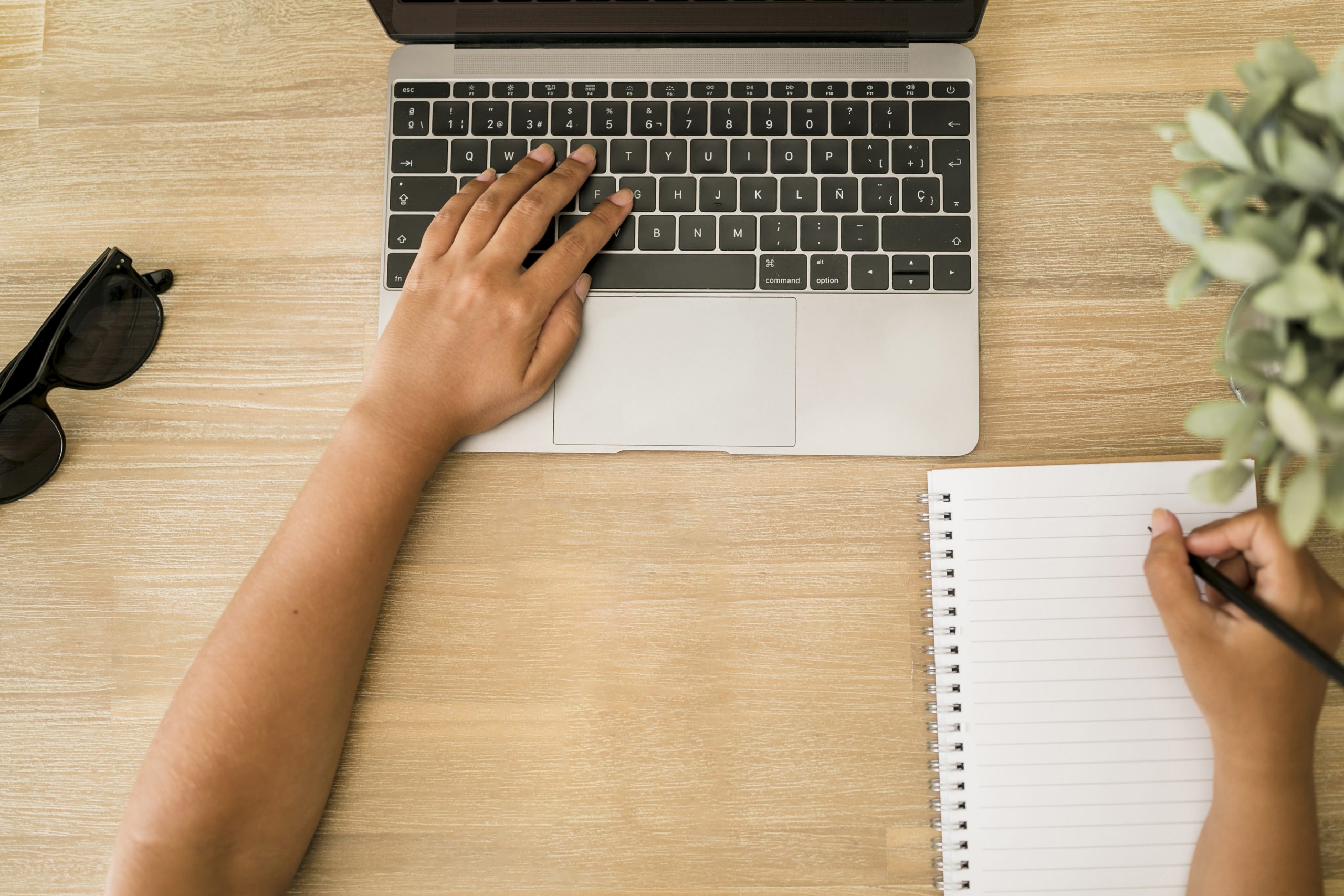 Faculdade EAD: aluno com o notebook e o caderno fazendo anotações da sua aula ead