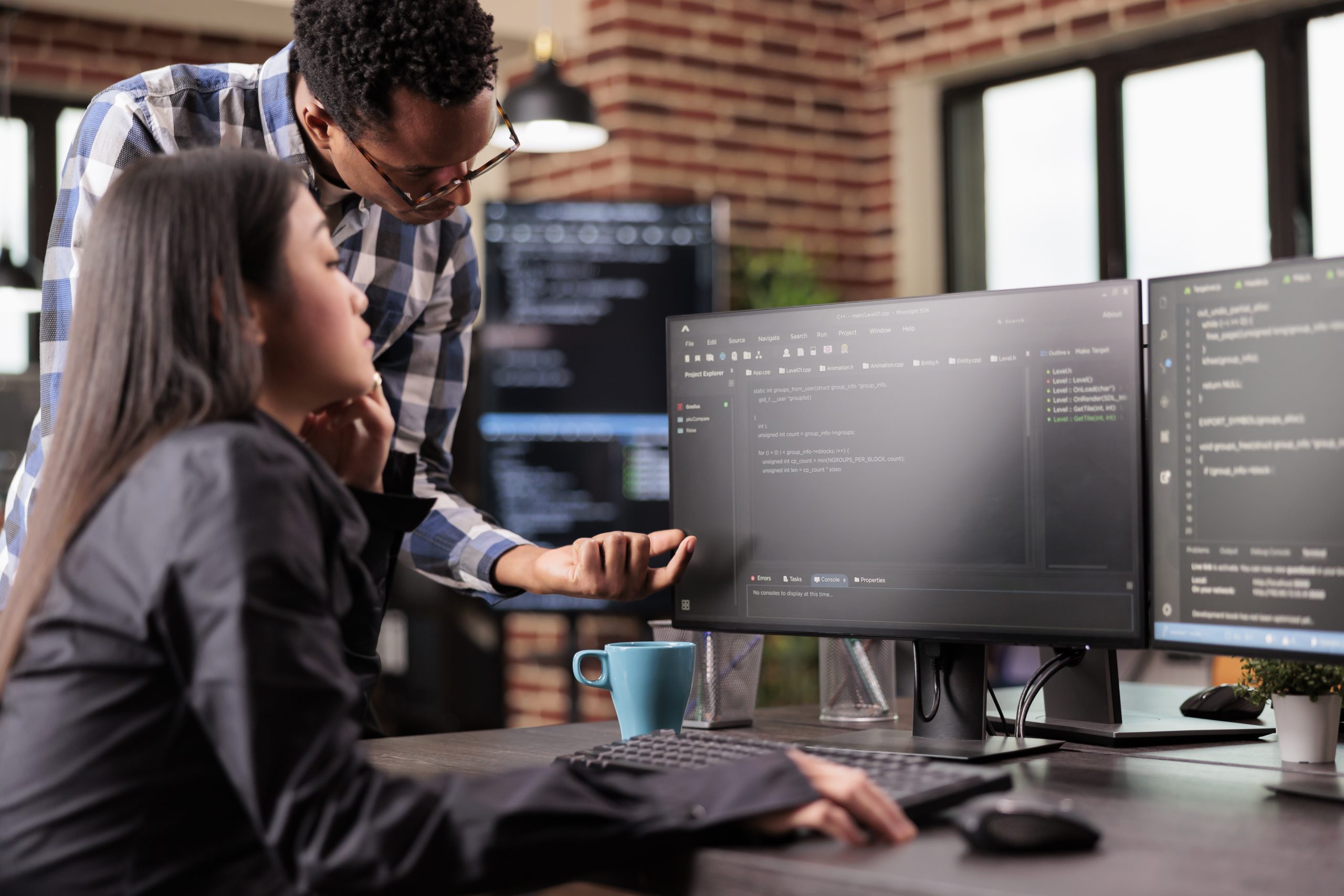 Analise e desenvolvimento de sistemas: dois profissionais da área em frente ao computador fazendo analise de códigos