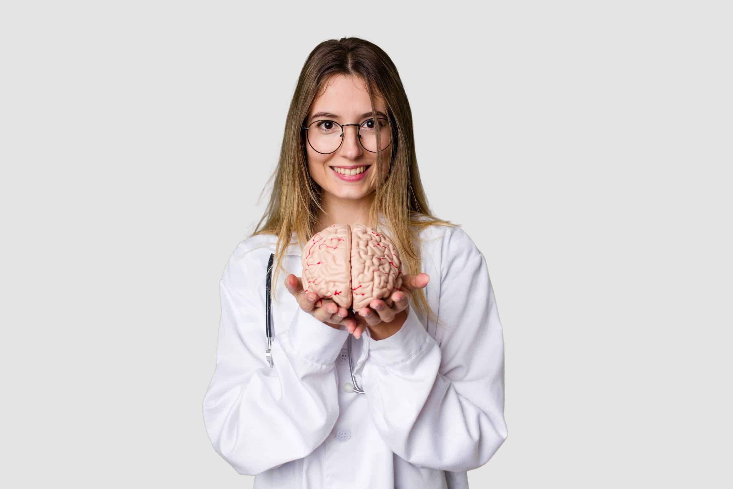 Gestão de tempo: mulher com um jaleco branco segurando um cérebro com as duas mãos