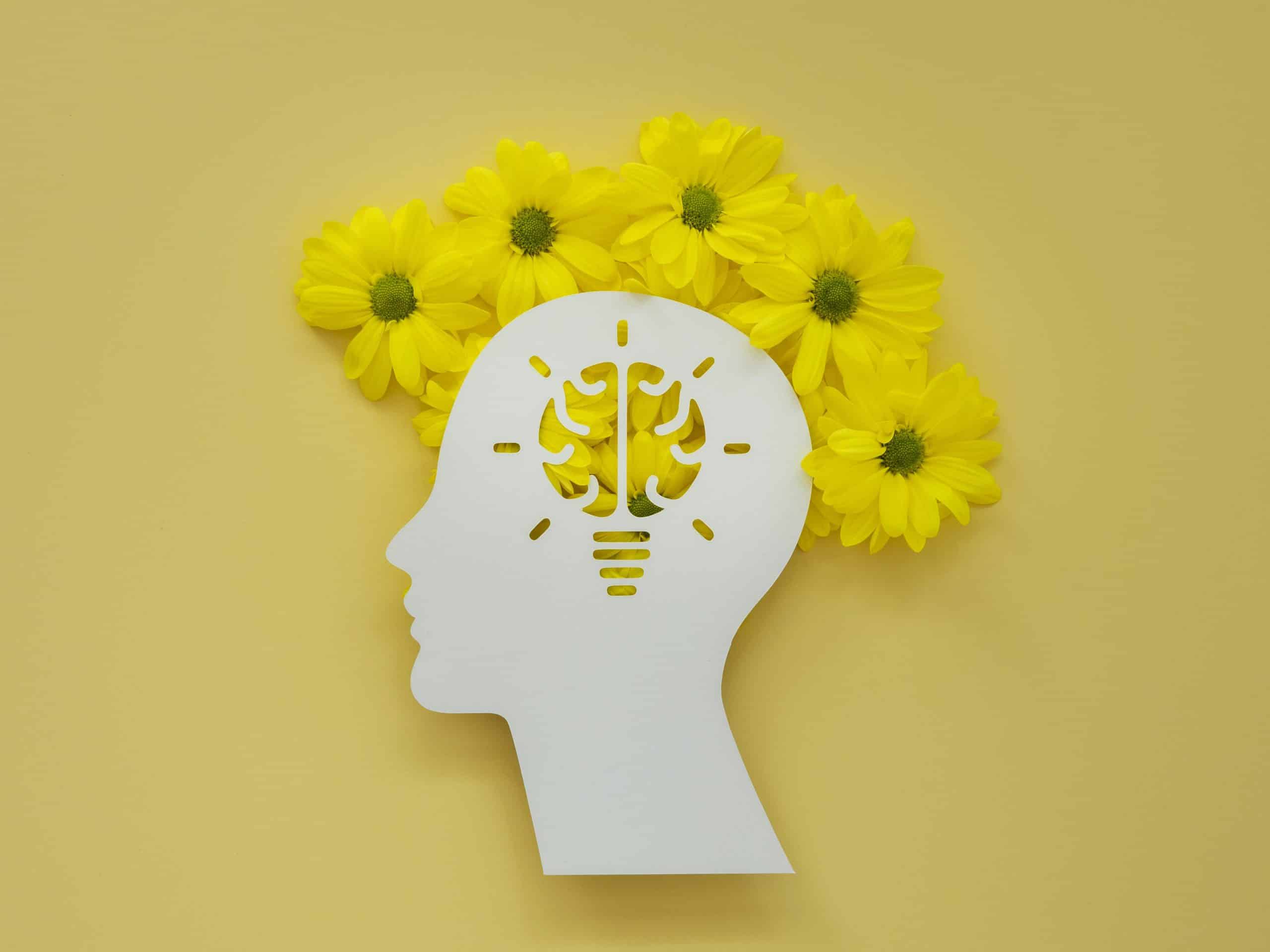Saúde mental da mulher: imagem que remete a forma de uma cabeça com flores ao redor