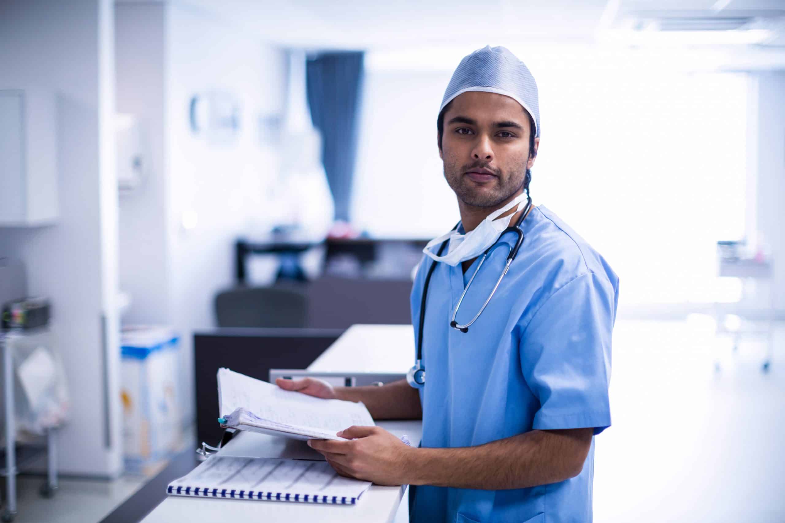 Técnico de enfermagem: técnico de enfermagem com uniforme azul conferindo as atividades