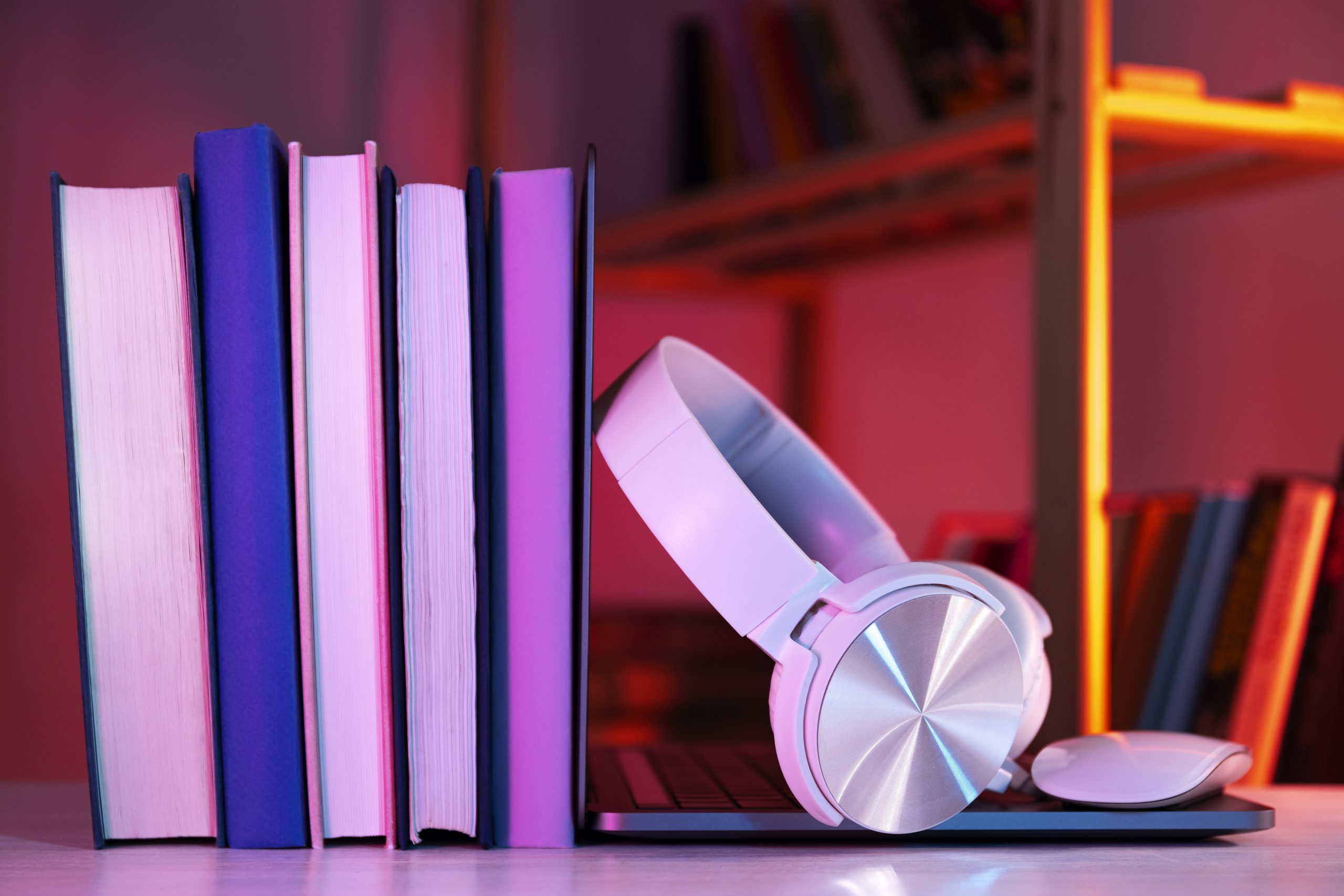 quatro livros em pé e um fone de ouvido sobre uma mesa