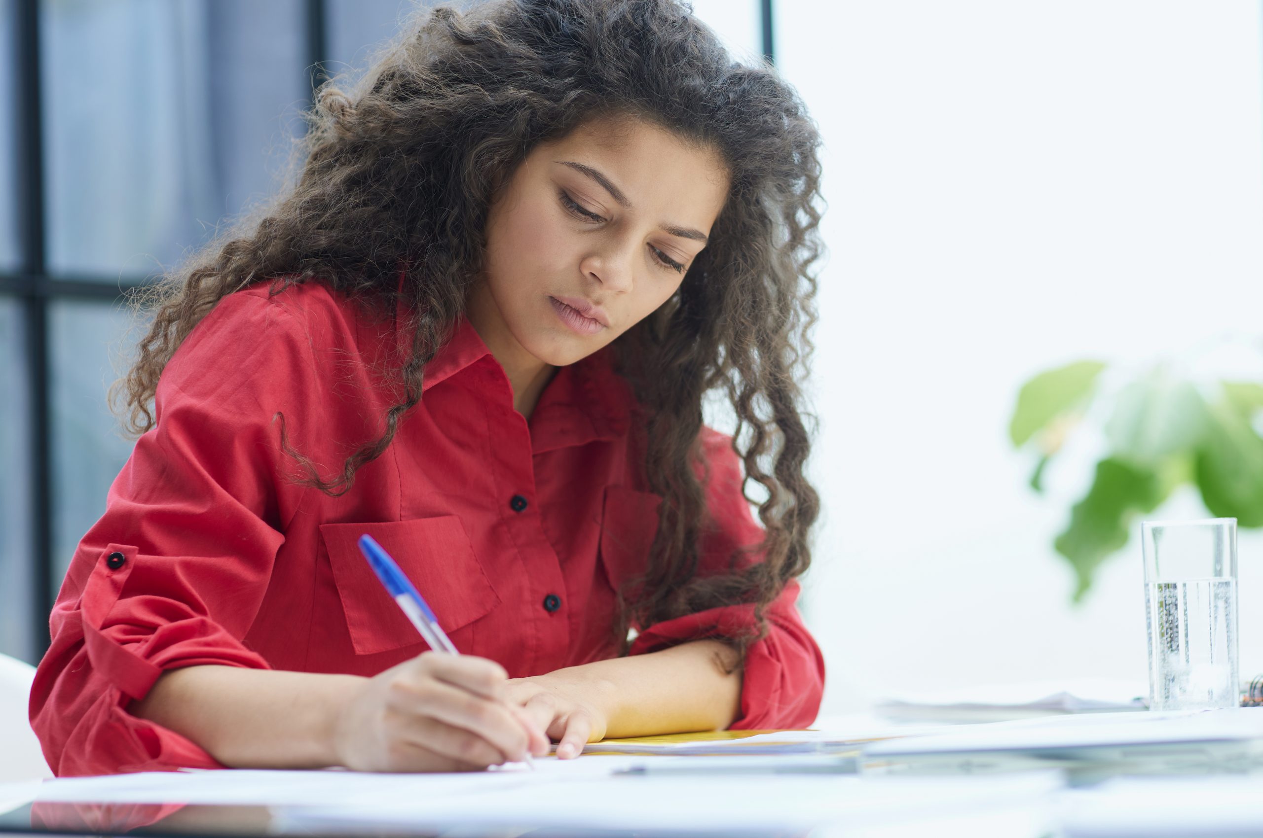 mulher em um ambiente de estudo, escrevendo em um caderno
