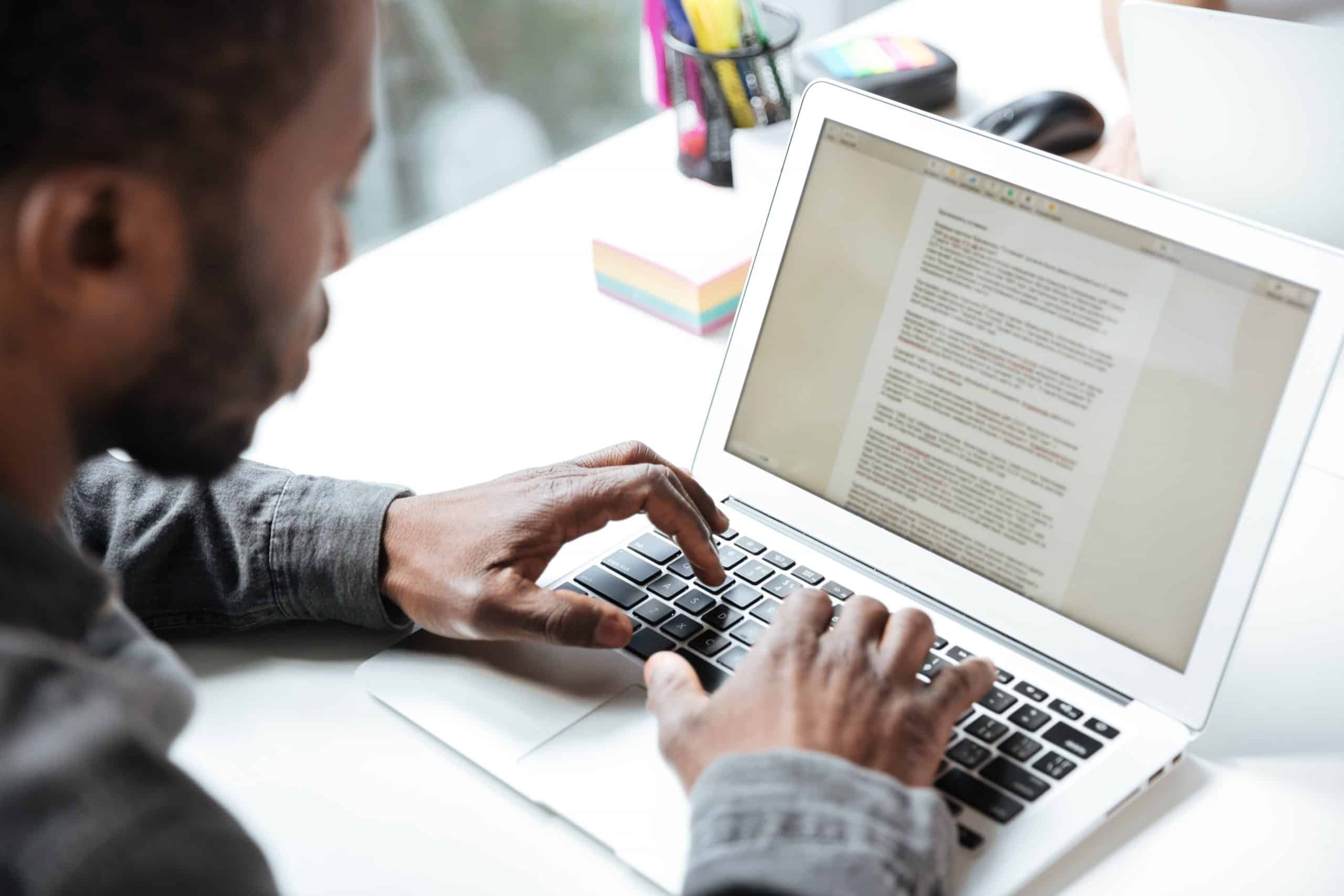 homem sentado em frente ao notebook praticando a escrita