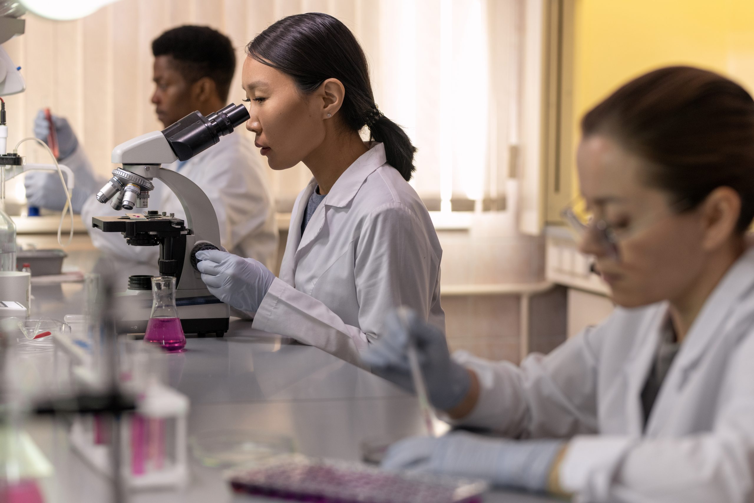 laboratório de biologia com alunos fazendo atividade com microscópio
