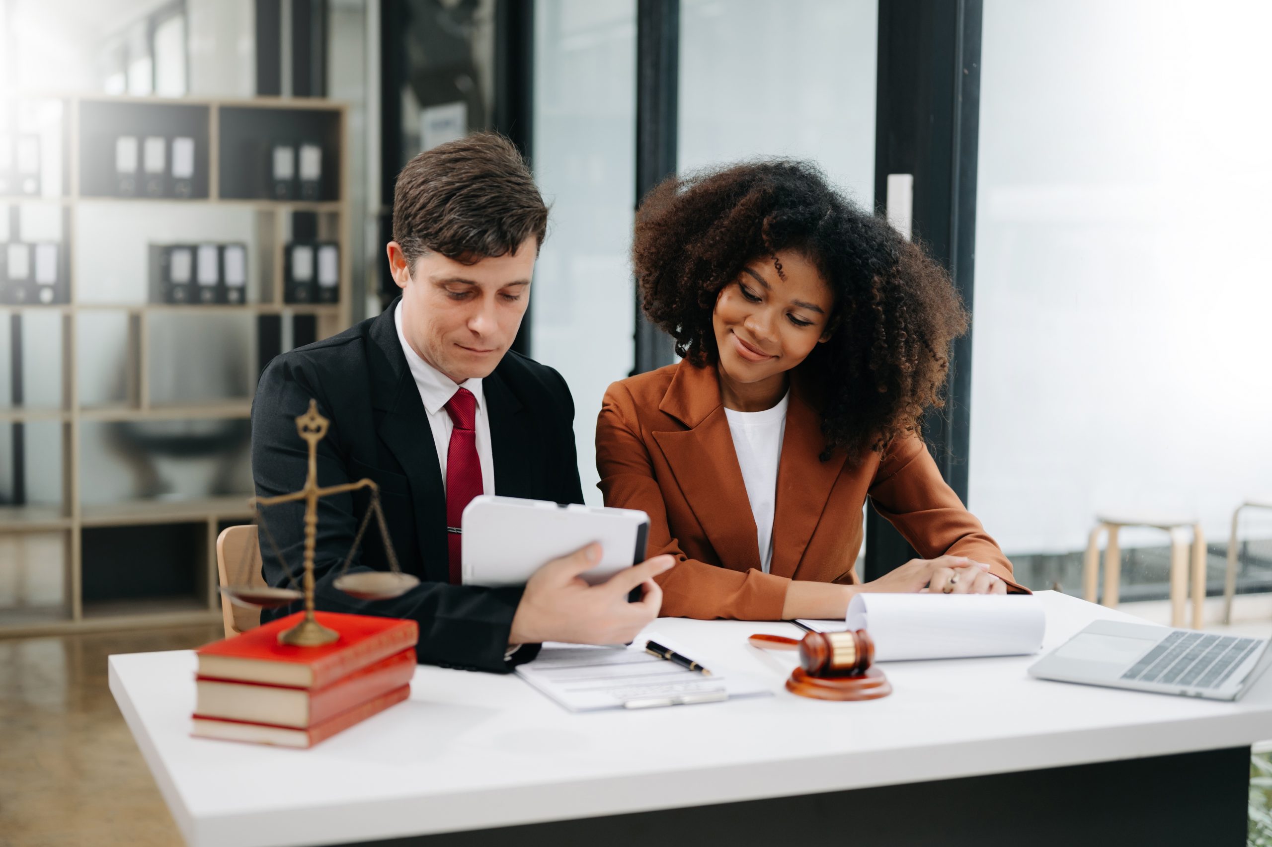 dois jovens adultos sentados analisando processos