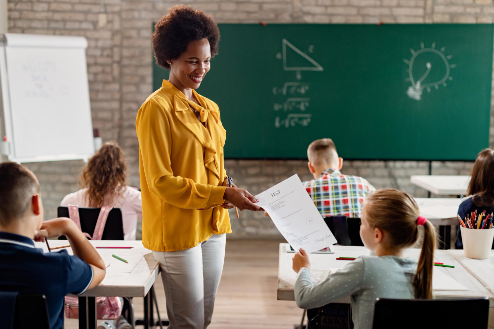 mulher em sala de aula entregando prova a um aluno