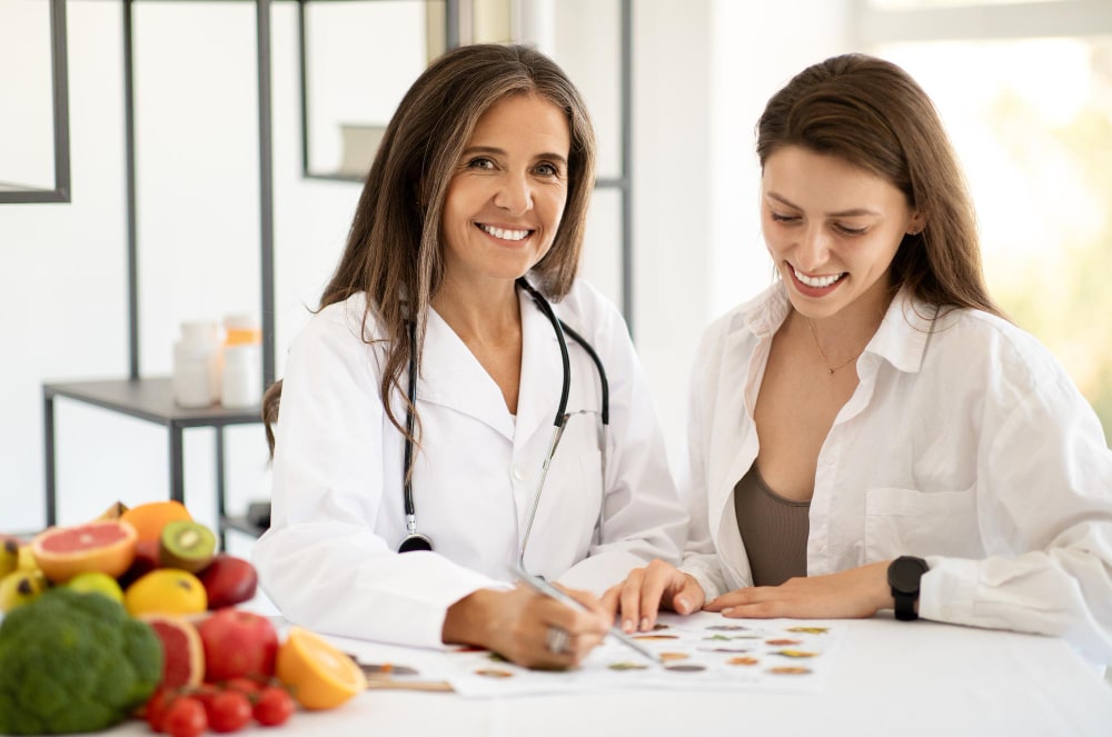 duas profissionais com jaleco branco, em ambiente profissional conversando sobre alimentos