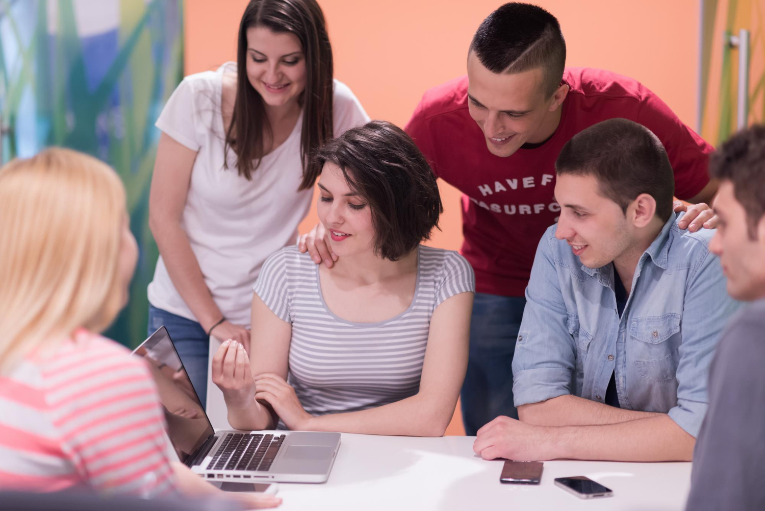 grupo de alunos reunidos em volta de um notebook
