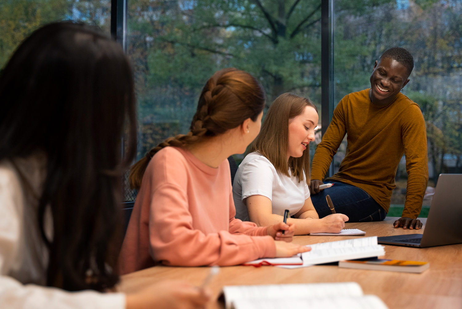 grupo de alunos estudando juntos na faculdade. Sobre a mesa cadernos e livros de estudos