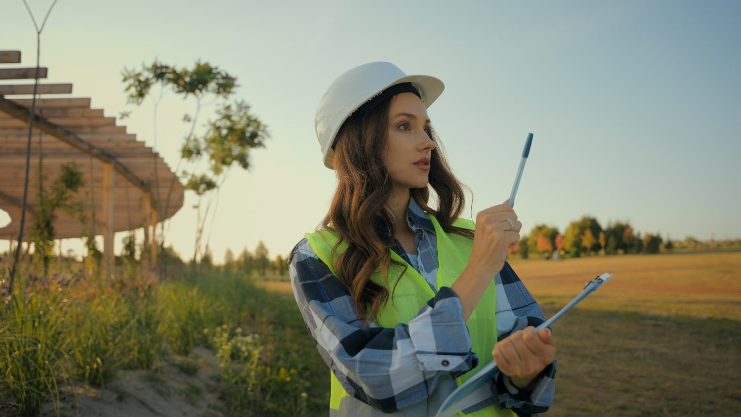 engenheira em meio a natureza com equipamentos de trabalho