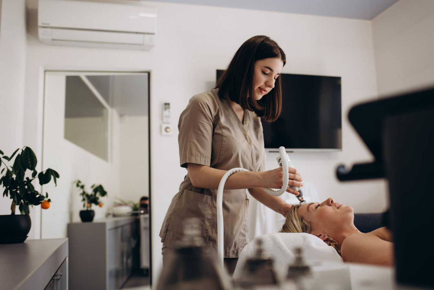 Esteticista faz a uma jovem um tratamento facial a vácuo para rejuvenescimento.